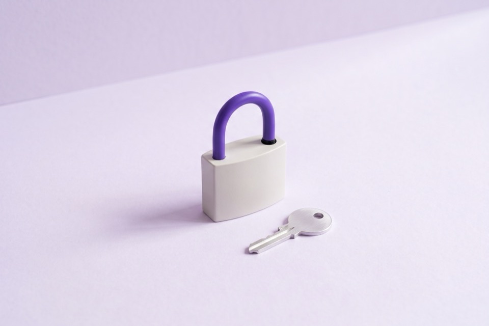 White padlock with a violet shackle and a silver key beside it